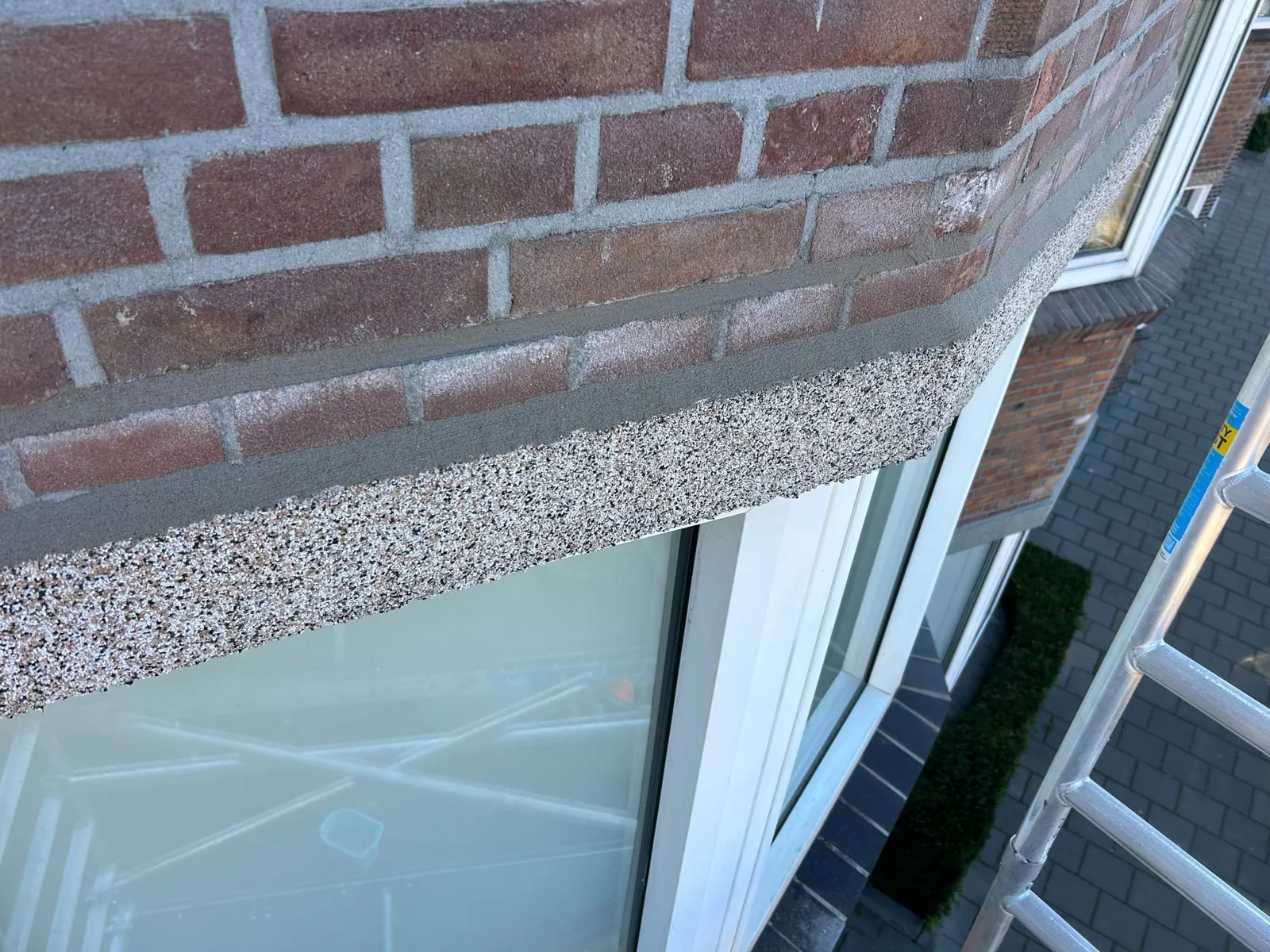 Schoongemaakte gevel na verwijdering van groene aanslag