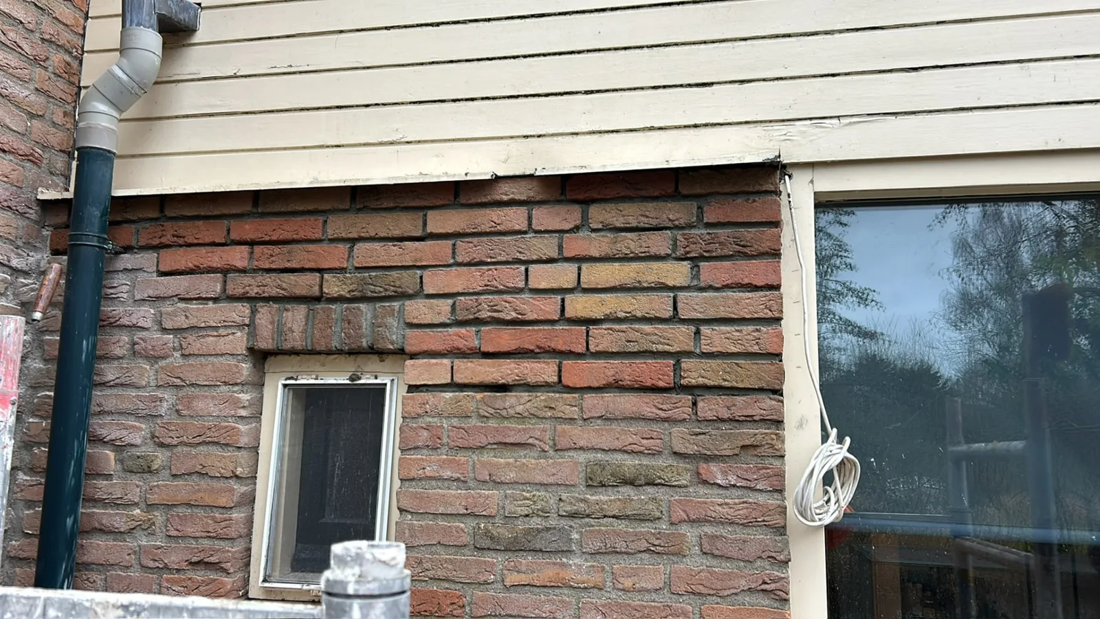 Gevel met opnieuw gevoegd metselwerk rond kozijn en pui