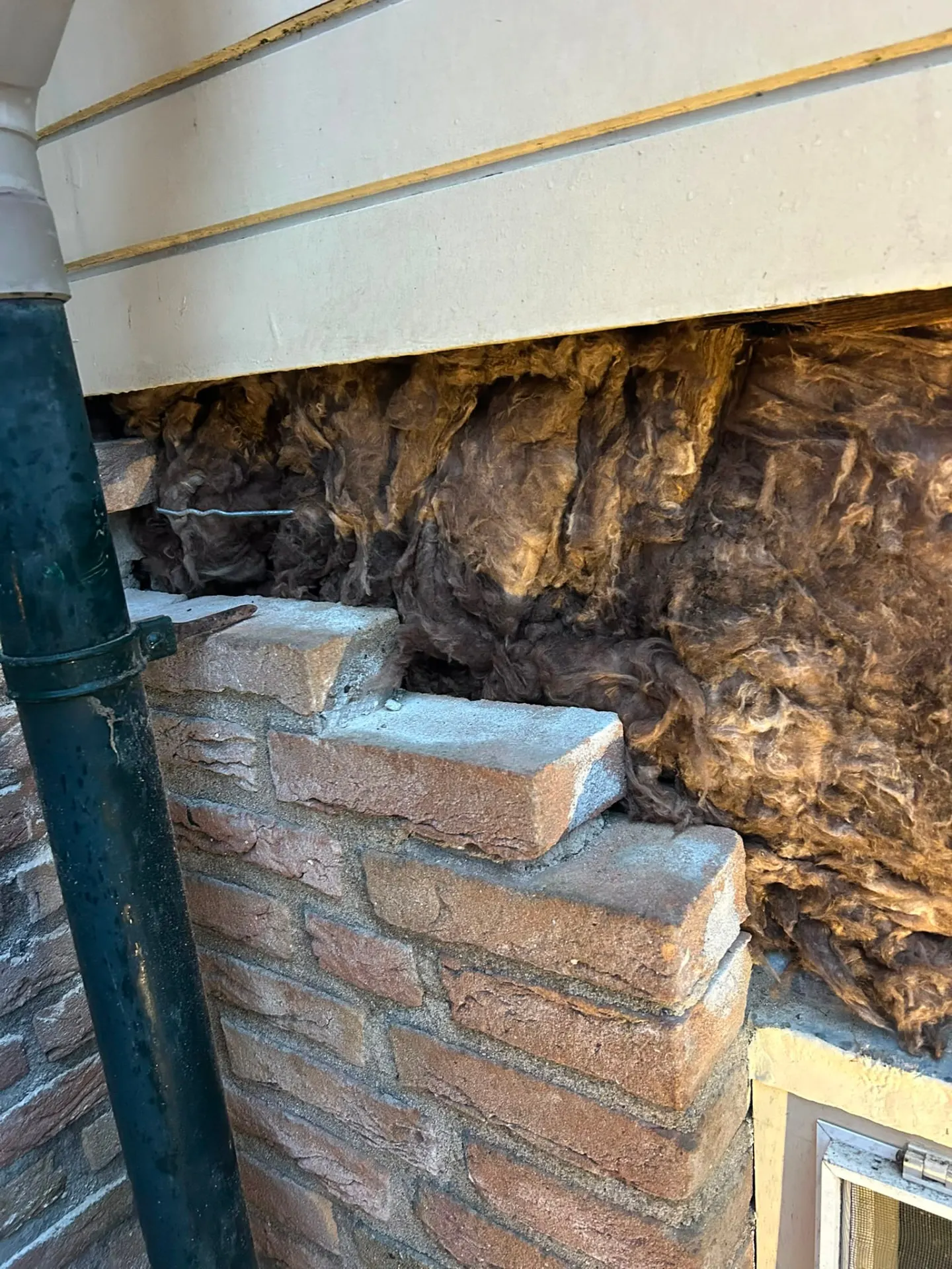 Blootgelegde spouw met isolatie boven een herstelde rollaag