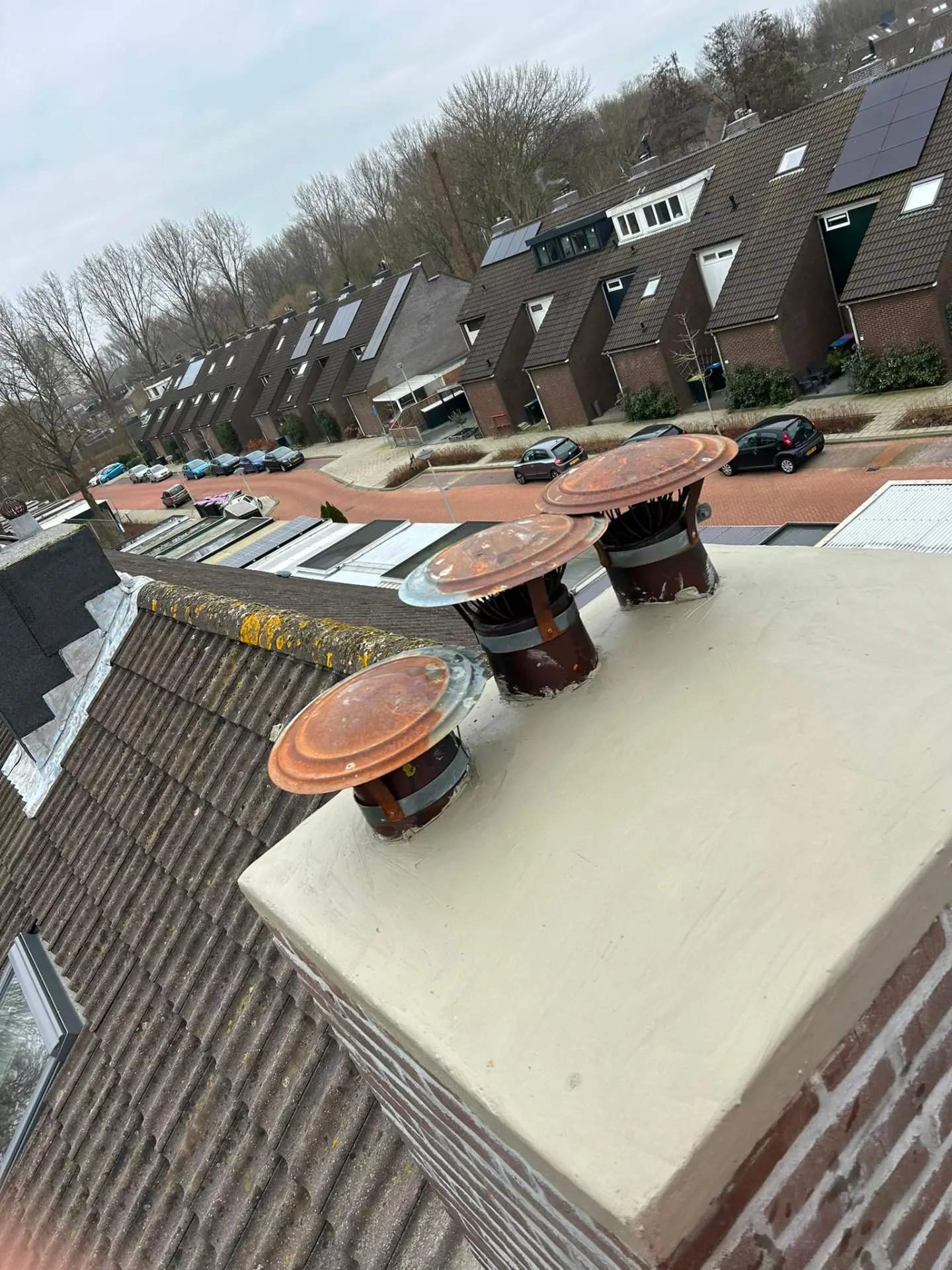 Volledig herstelde schoorsteen met vlakke afwerking en nieuwe potten