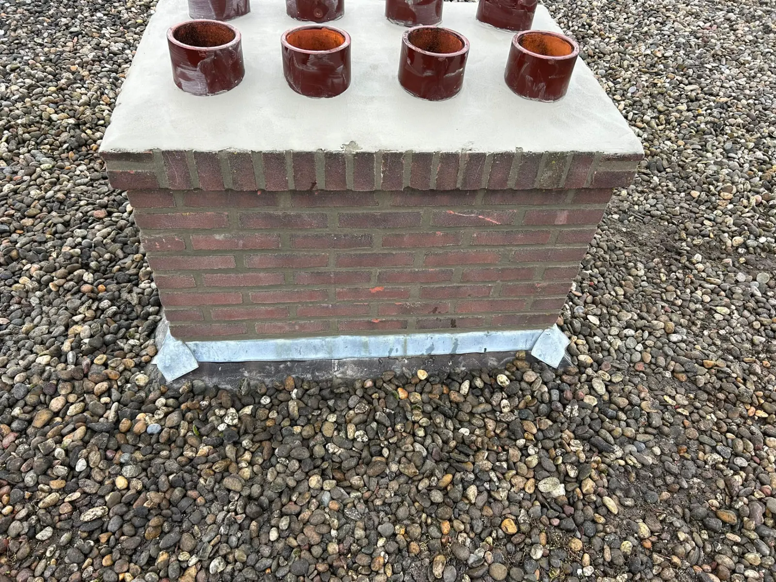 Detail van de schoorsteenvoet met zinken loodslabbe waterdicht afgewerkt