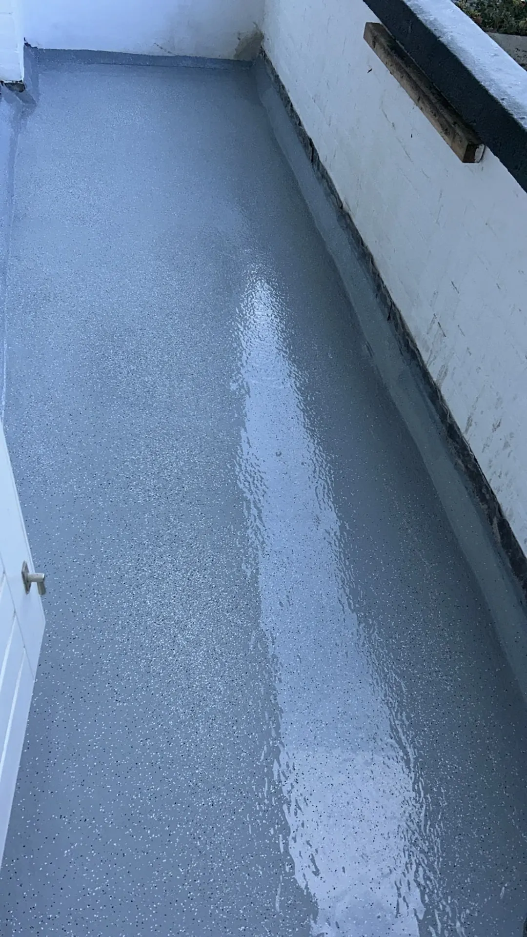 Balkon met verse grijze vloercoating en herstelde randafwerking