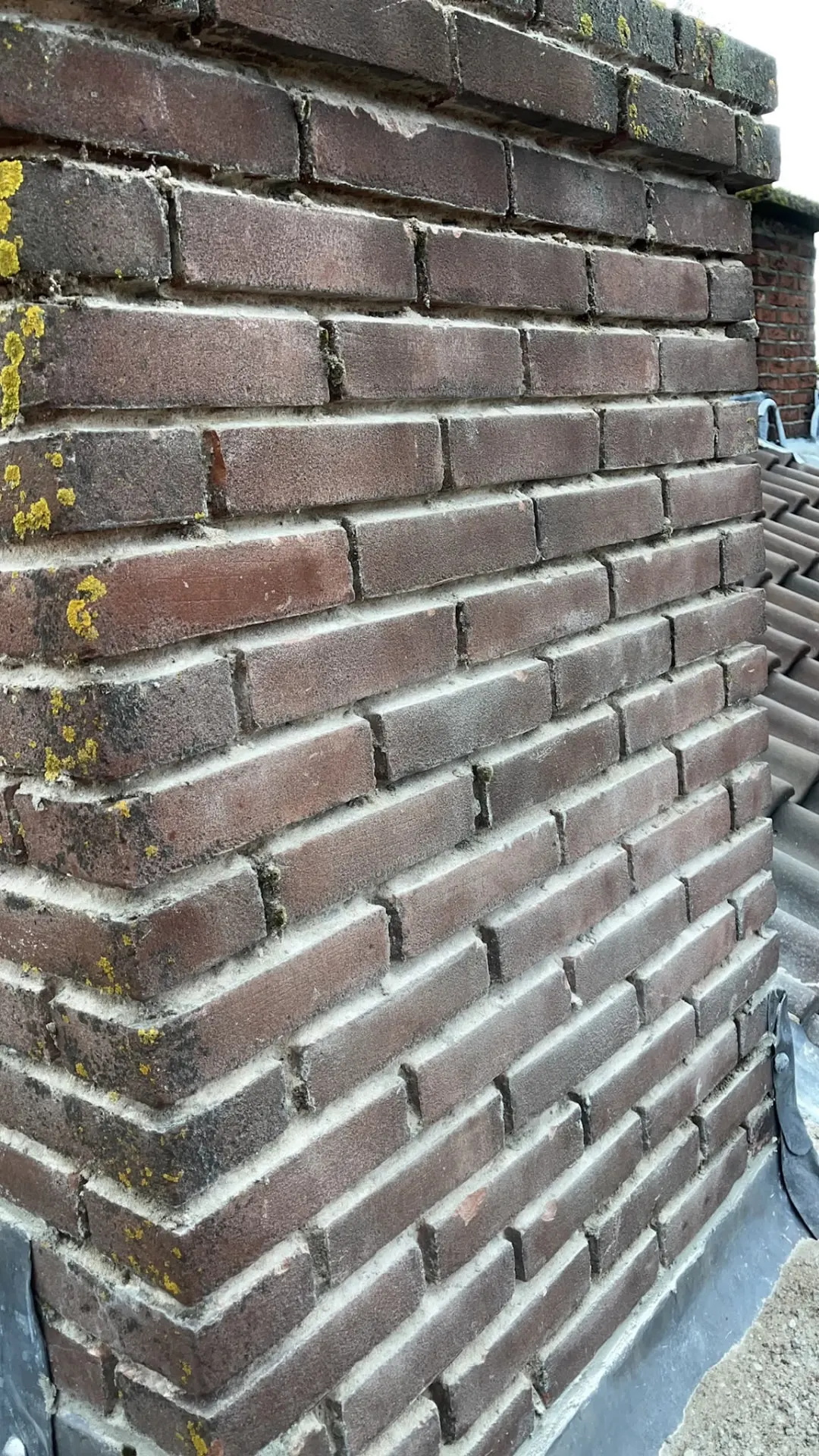 Detail van vernieuwd voegwerk op een oude gemêleerde schoorsteen