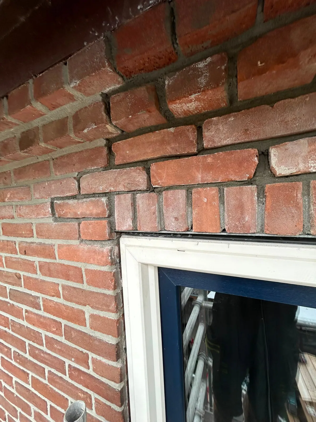 Herstelde rollaag met nieuwe stenen boven een raamopening