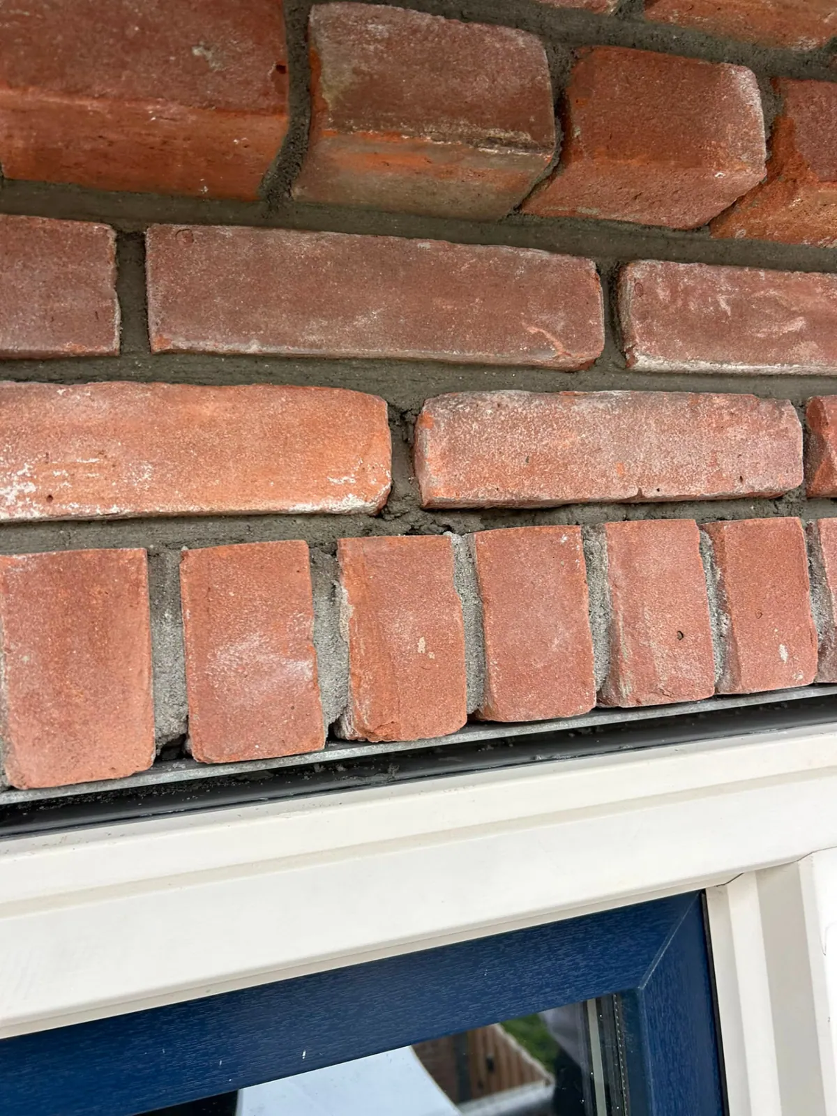 Detail van vers voegwerk in een strak gemetselde rollaag