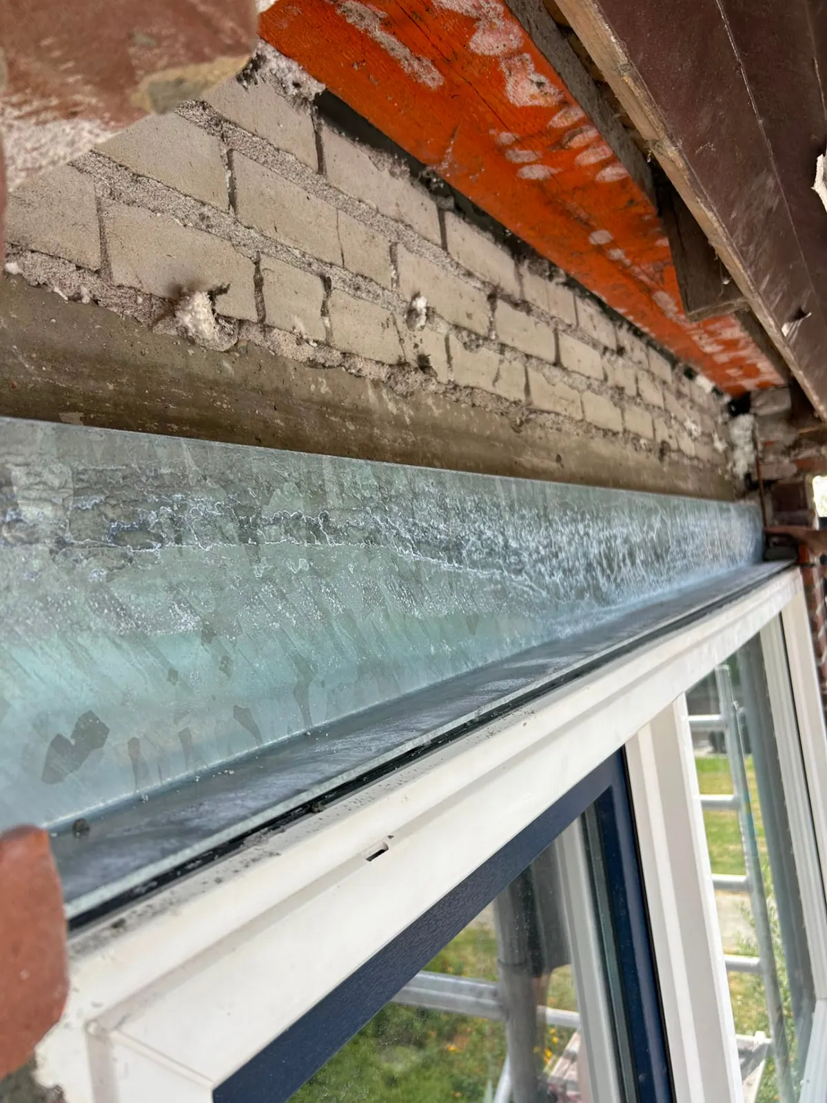 Nieuw geplaatste stalen latei boven een kozijn tijdens gevelherstel