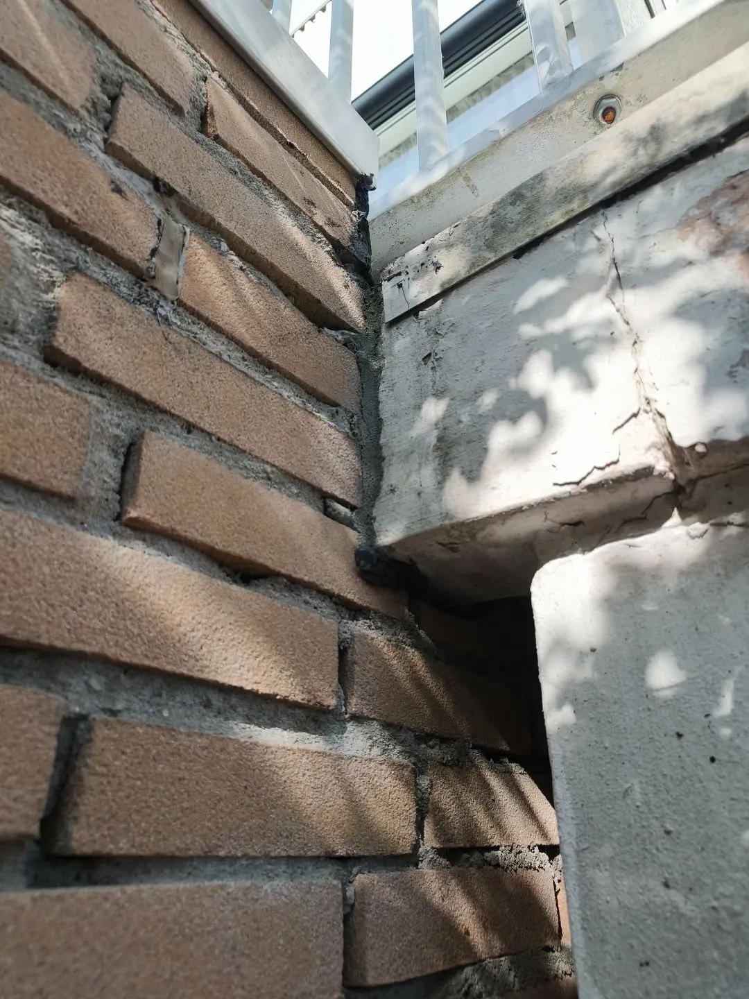 Scheur en beschadigd metselwerk in een gevelhoek voor herstel