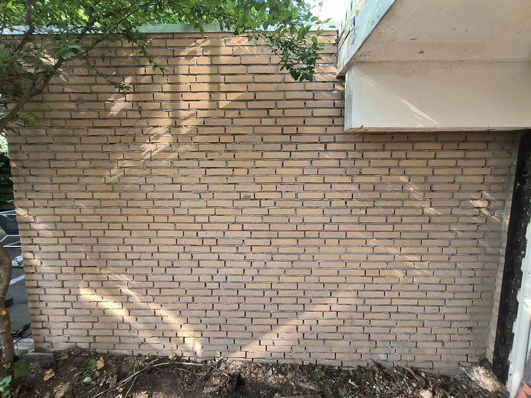 Gele bakstenen muur volledig opnieuw gevoegd