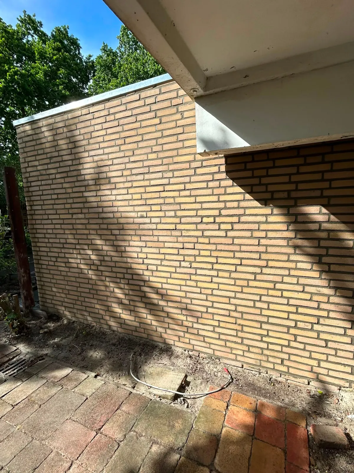 Gereinigde gele gevel na verwijderen van aanslag