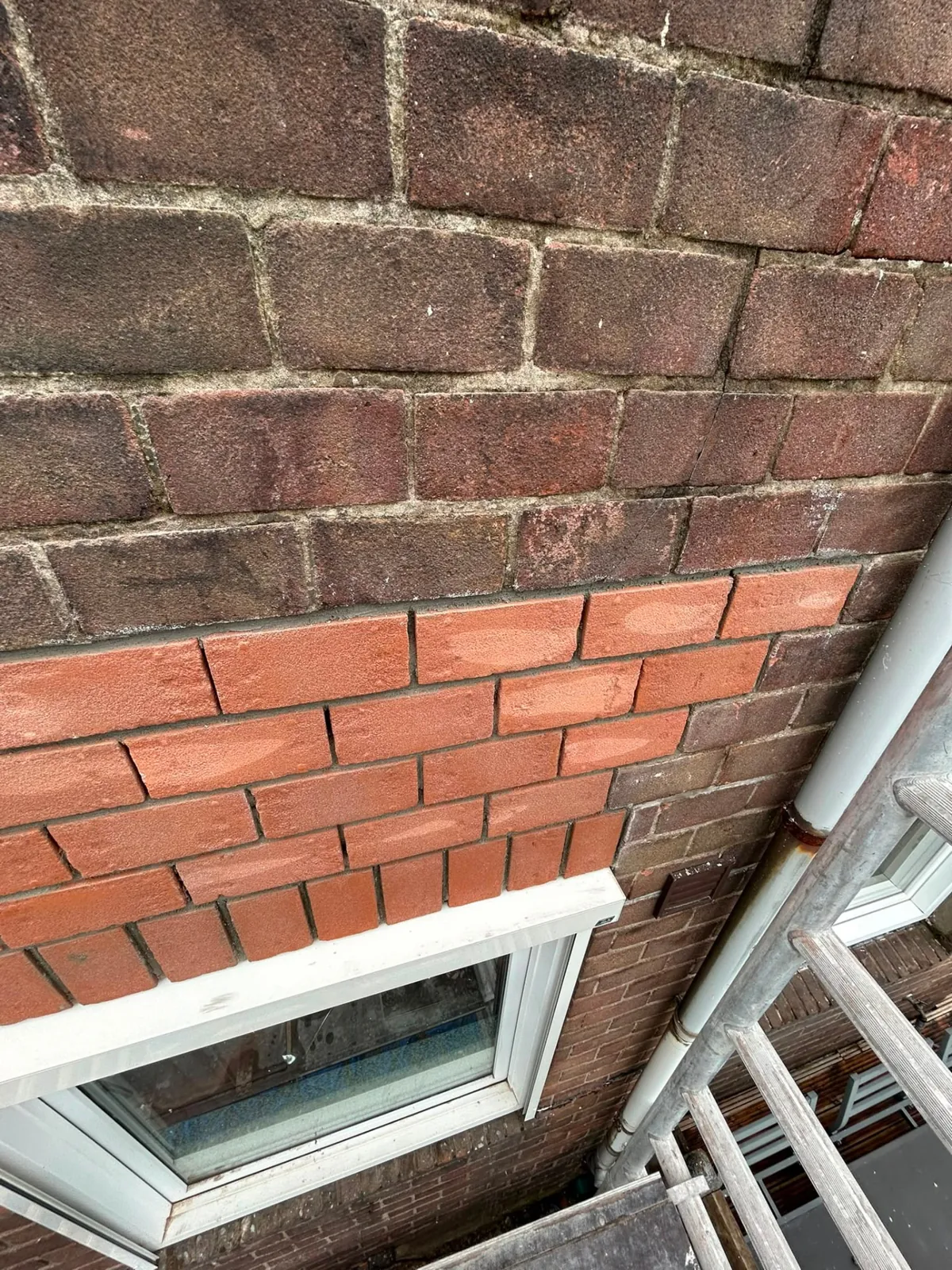 Ingeboet rood metselwerk boven een raamkozijn