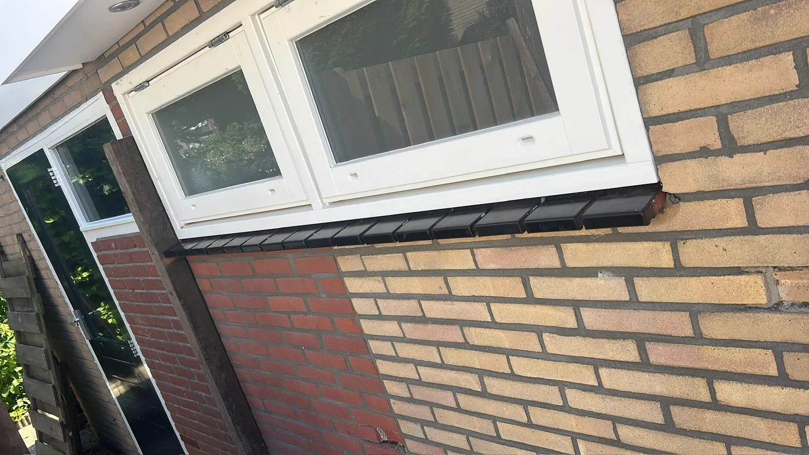 Nieuwe waterslag en latei onder een kozijn in de gevel