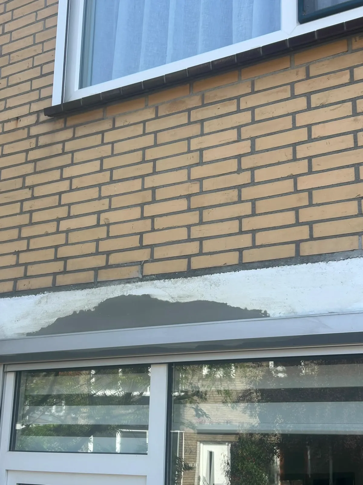 Herstel van de betonnen latei boven een pui in de gevel