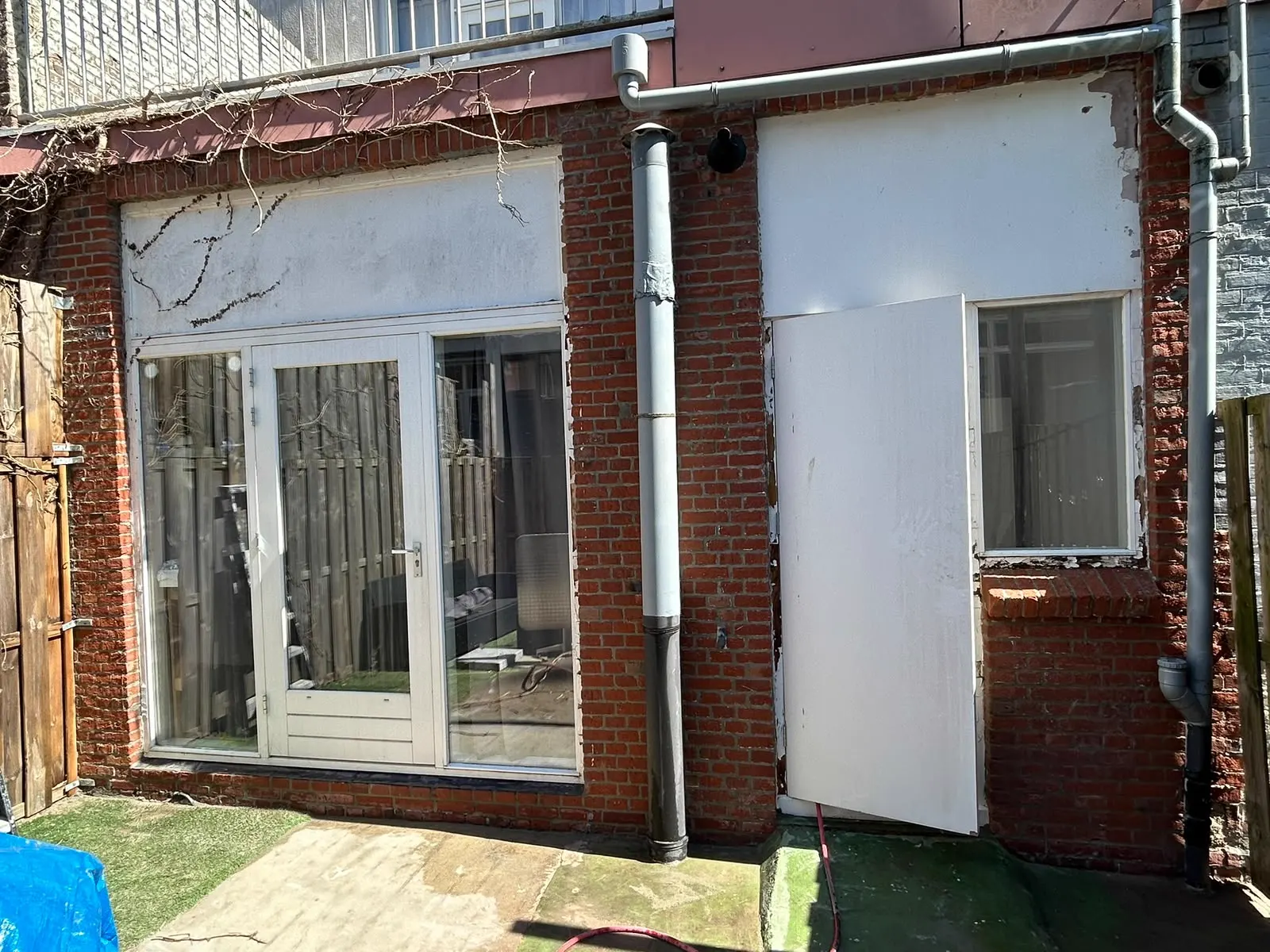 Achtergevel met stucwerk en metselwerk voor renovatie