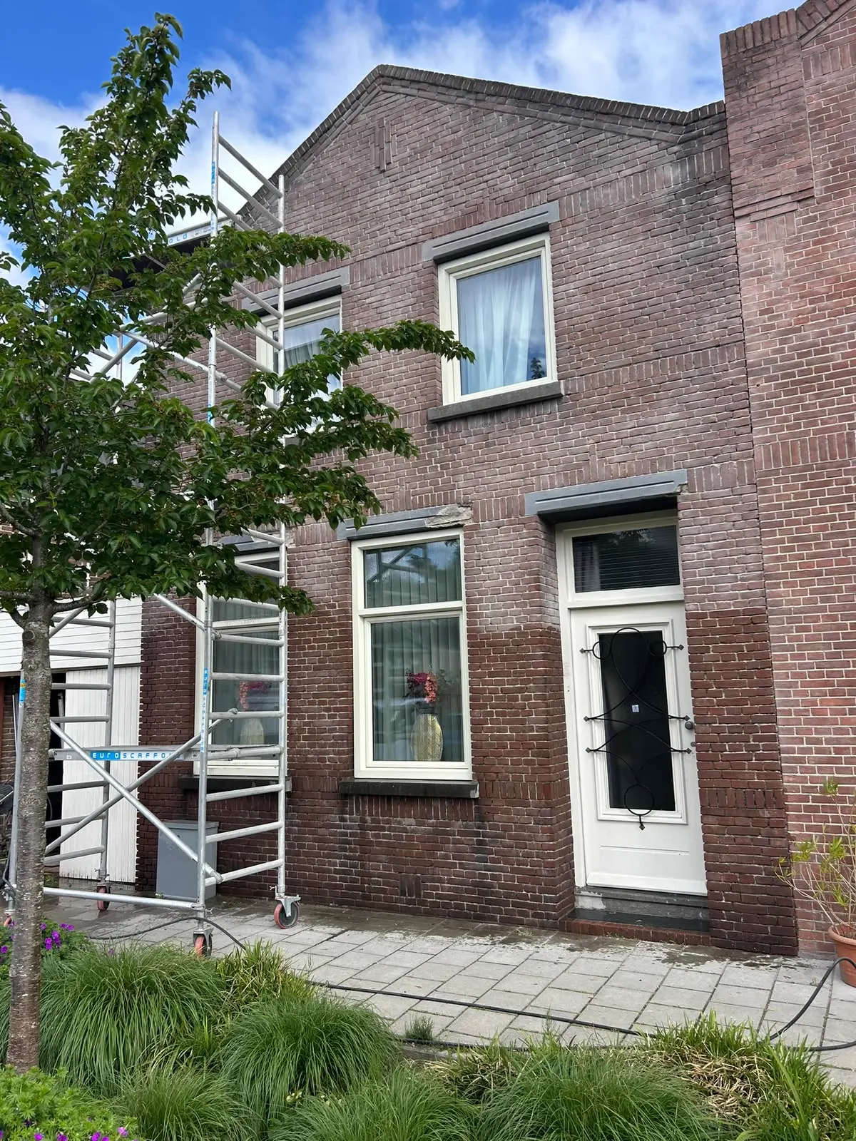 Woning met rolsteiger tijdens gevelrenovatie en voegwerk