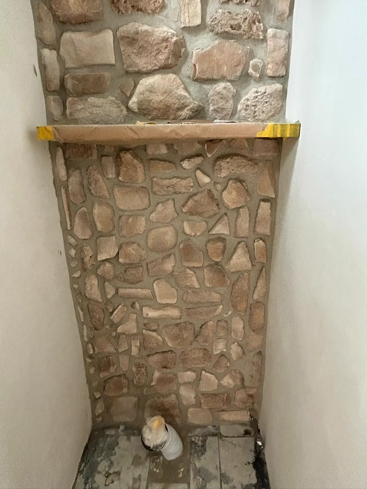 Afgewerkte natuursteenstrips met verse voeg op een binnenwand