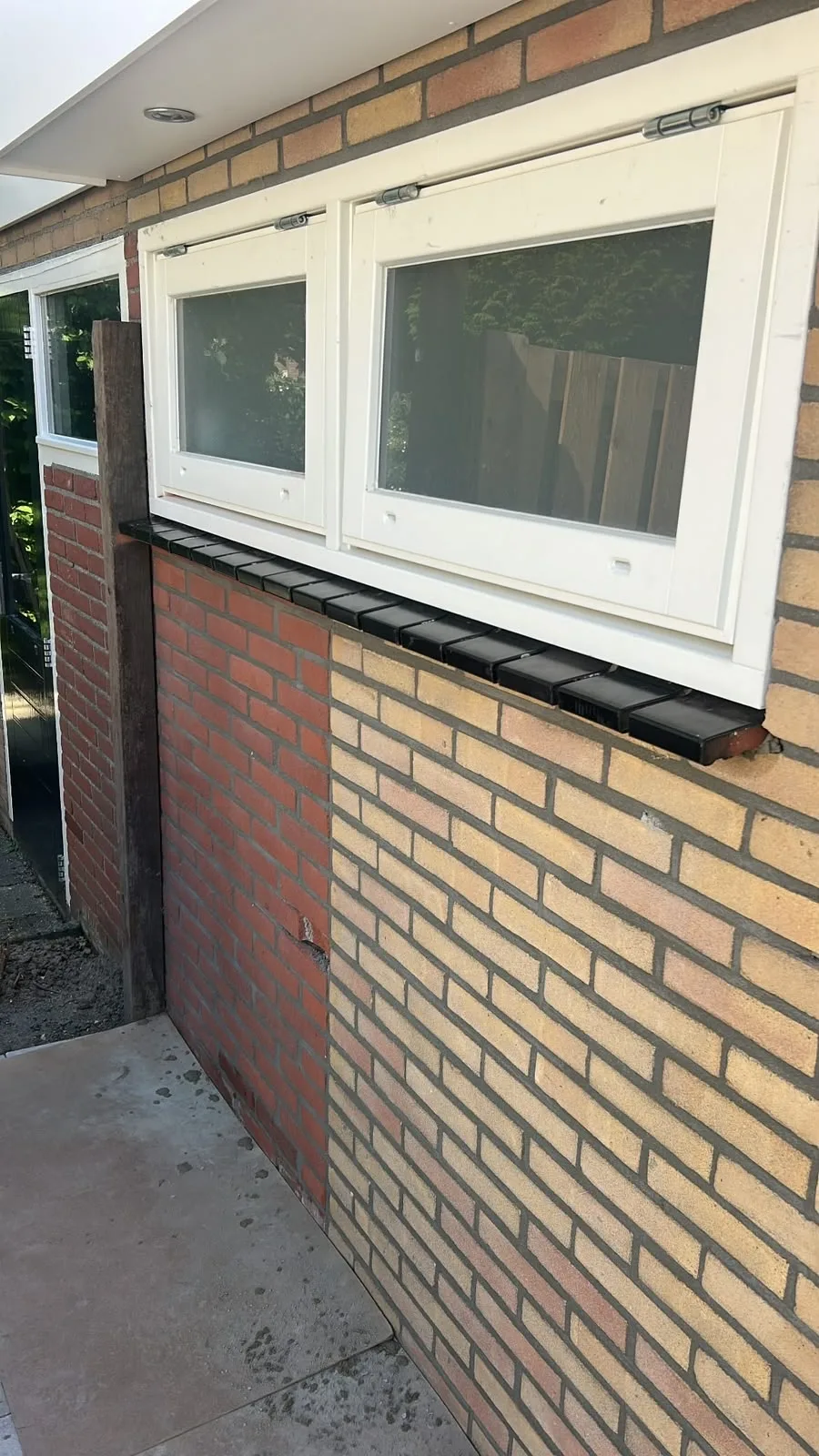 Nieuwe raamdorpels onder kozijnen in een gele bakstenen gevel
