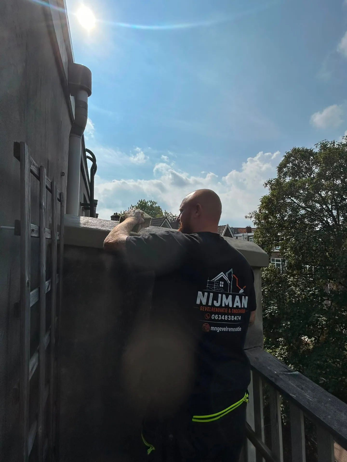 Mickey Nijman werkt de dakopstand van een Amsterdams pand af